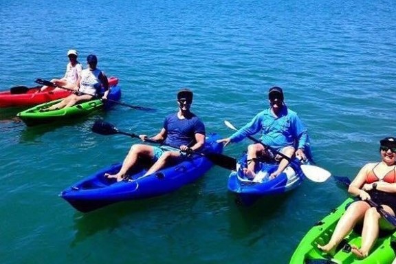 a group of people in a small boat in a body of water