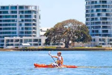 a person riding on the back of a boat in a body of water